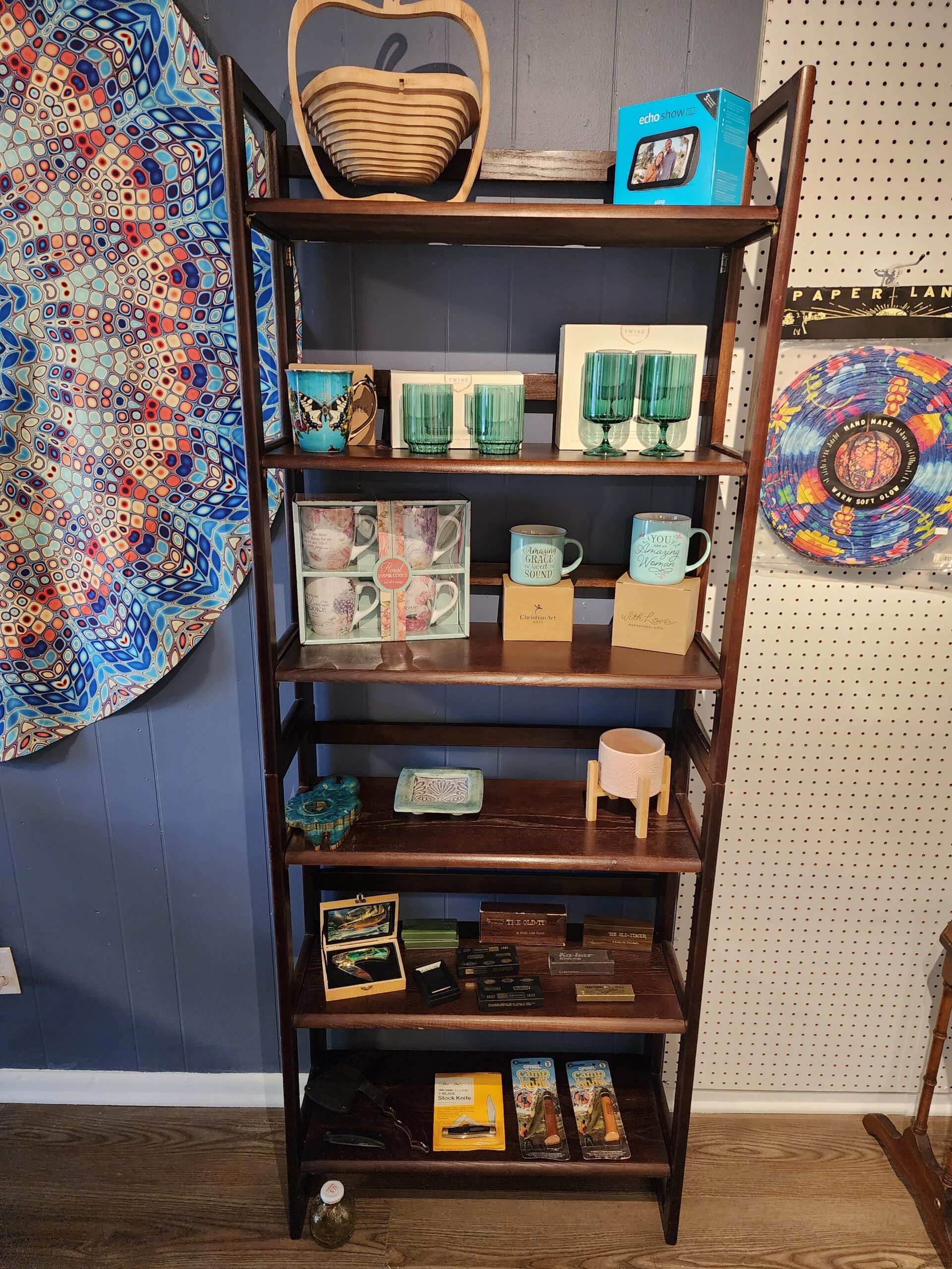 Shelves at Hodgepodge with various items including drinking glasses and vintage pocket knives