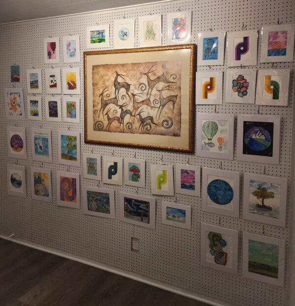 Framed paintings and small artworks on the gallery wall at HodgePodge in Austin