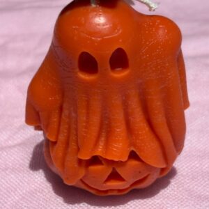 Ghost hovering over pumpkin candle